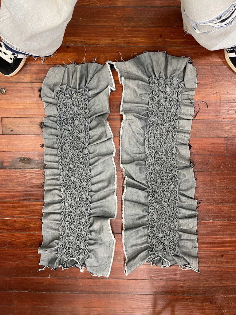 Two unfinished denim panels showing dense Canadian smocking in development