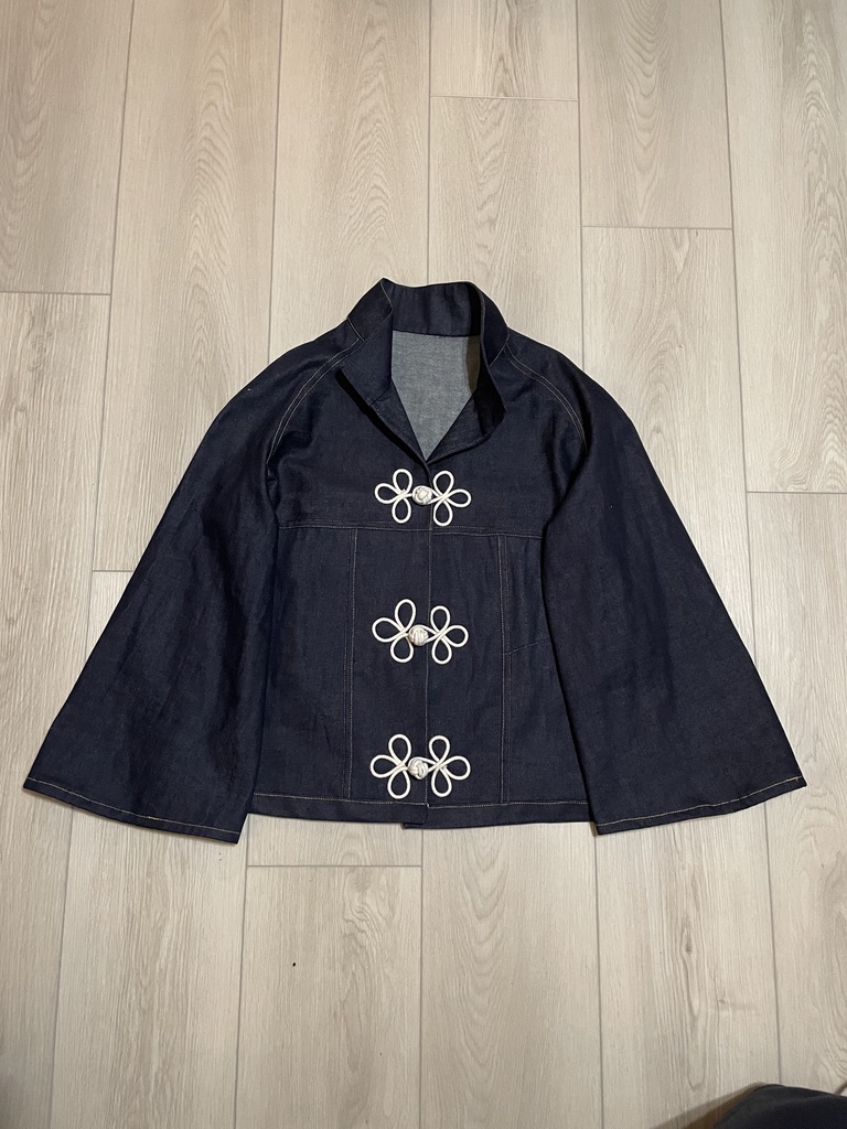 Dark indigo jacket with wide sleeves and three oversized white frog closures