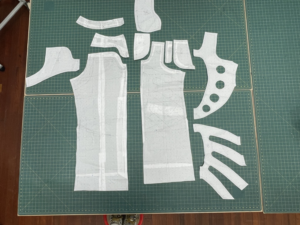 Tension System 01 jacket pattern pieces arranged across two gridded cutting tables